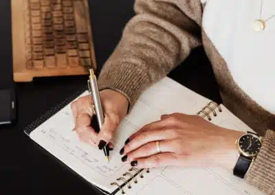 Un employé ou cadre de bureau utilise un stylo d'entreprise haut de gamme et personnaliser pour renseigner des informations dans son agenda