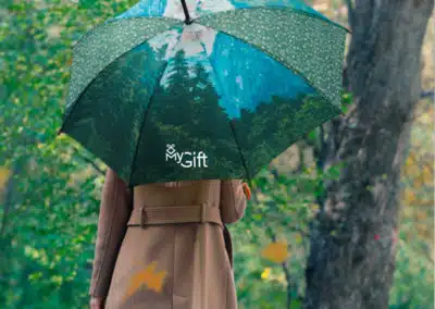 Un parapluie a motif naturel affichant un logo à utiliser comme objet publicitaire